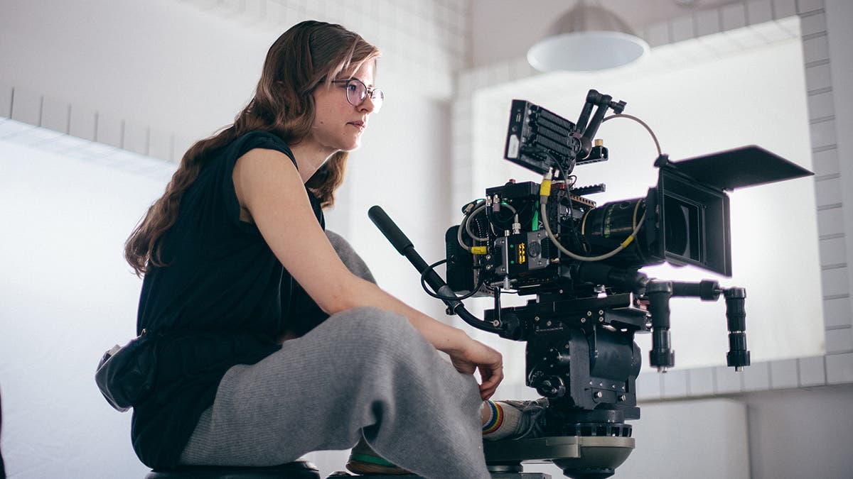 A woman is a cameraman behind a camera on a crane. Filming a mov