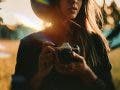 a female photographer holding a camera in a field