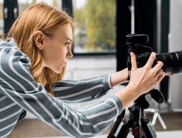 side view of young female photographer working with professional