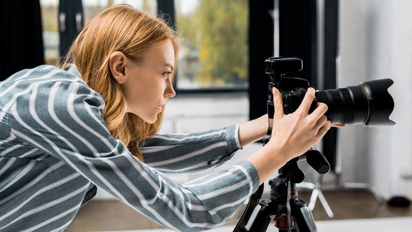 side view of young female photographer working with professional