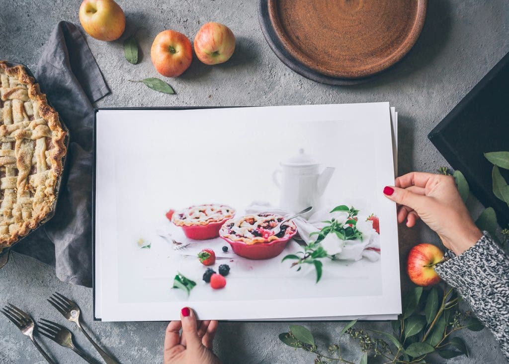 A professional photographer shows prints of their work