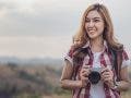 A tourist woman taking a photo with her mirrorless camera in nature