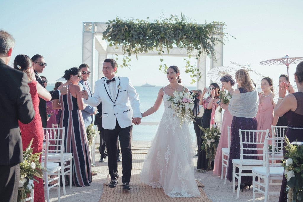 a wedding couple walking back down the aisle at the beach