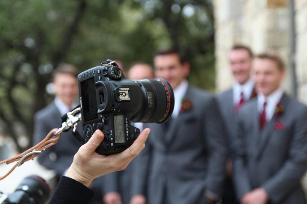 a photographer taking pictures of the groomsmen