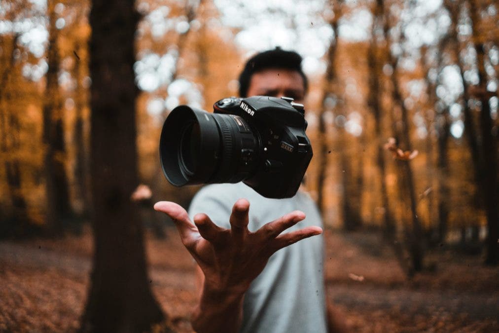 a photographer tossing a DSLR into the air