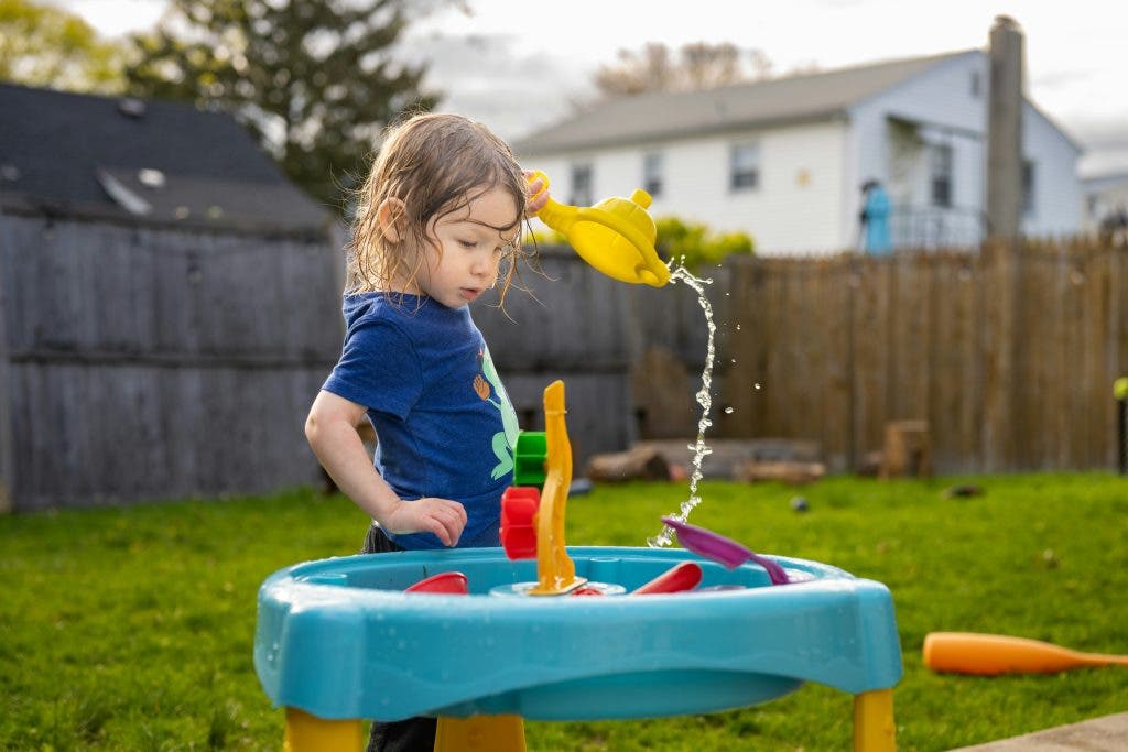photo of kid playing around in the backyard during the summertime
