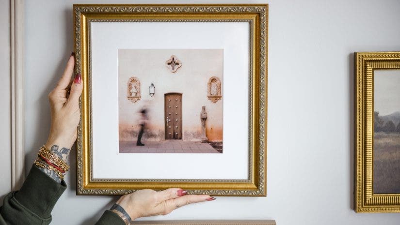 Woman hanging a framed printed photo