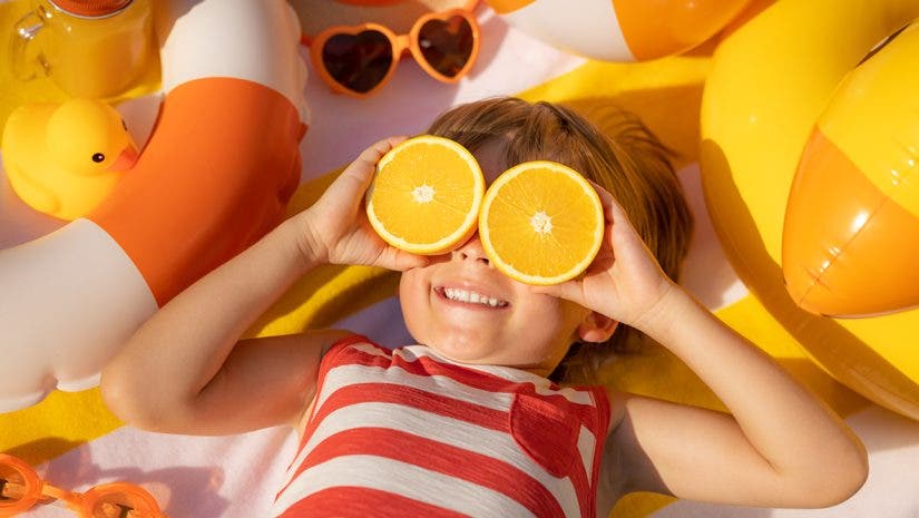 a photograph of kid sunbathing at the beach in the summer
