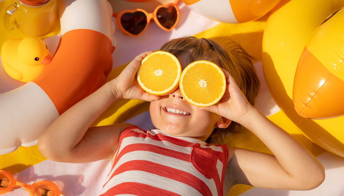 a photograph of kid sunbathing at the beach in the summer