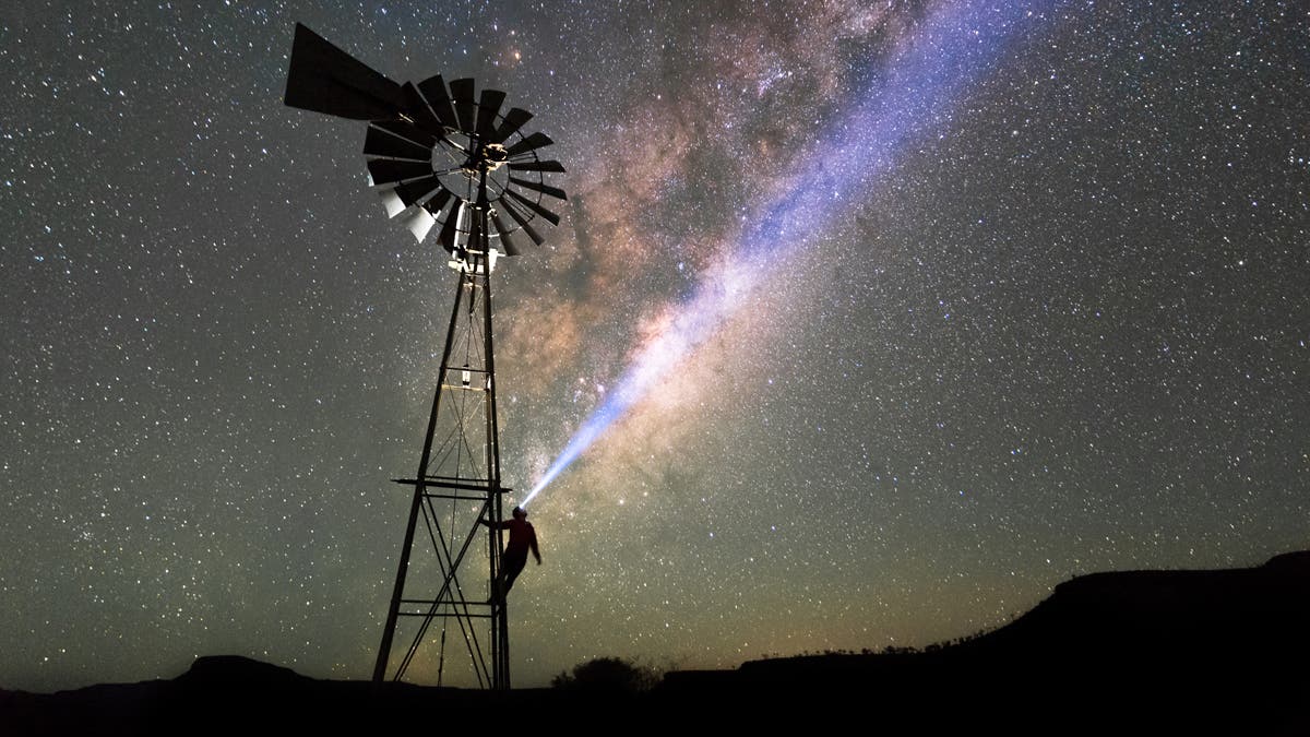 Man on a windmill with Milky Way sky