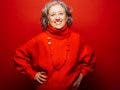 Senior smiling woman red clothes over a red background