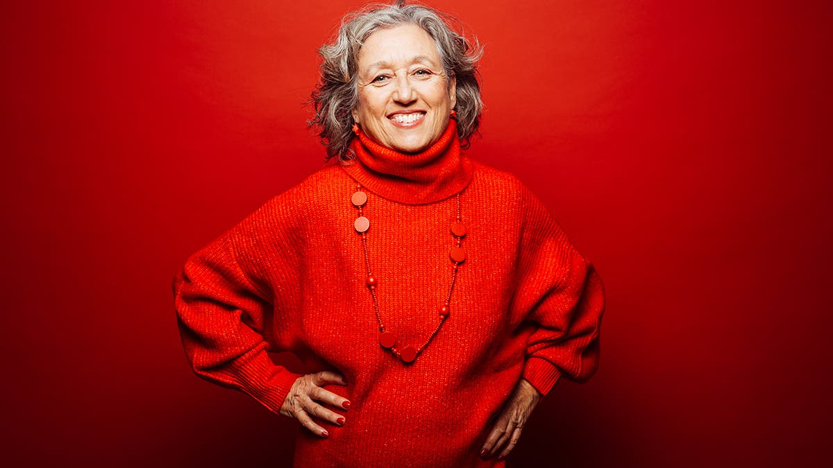 Senior smiling woman red clothes over a red background