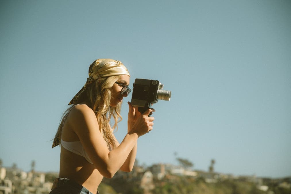 a girl holding a camera in a summer themed photo