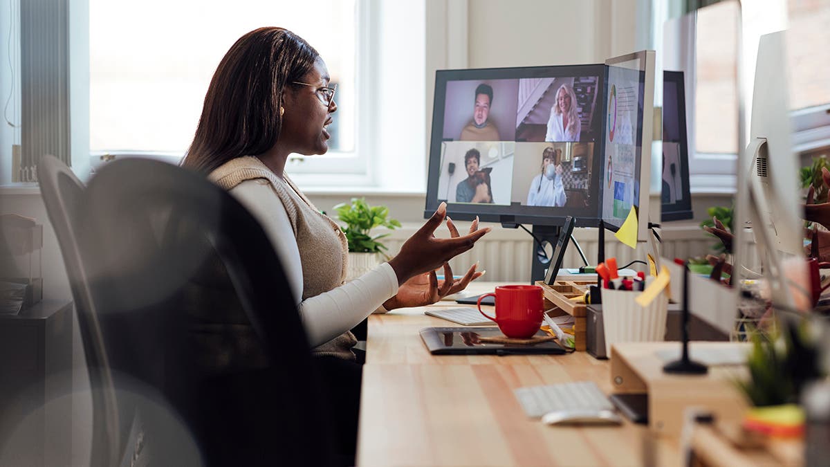 A side view of a manager speaking to her staff who are working from home. She is having a team briefing and getting up to date with everyones progress. She is working in her office in Newcastle Upon Tyne in the North East of England.