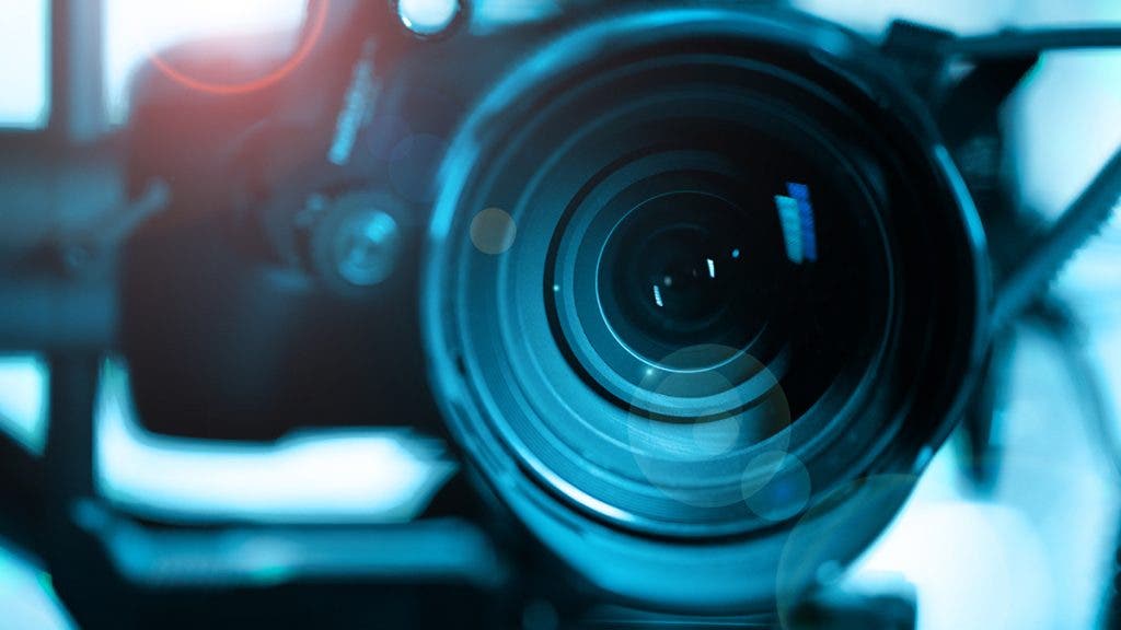 Close-up of modern black mirrorless digital video camera on stabilizer. Cinematic equipment concept.