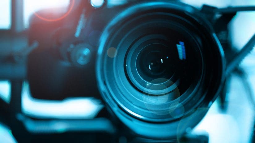 Close-up of modern black mirrorless digital video camera on stabilizer. Cinematic equipment concept.