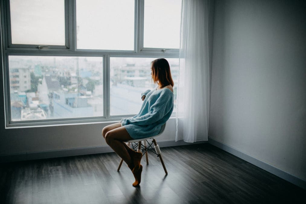 girl sitting in a chair looking out a window