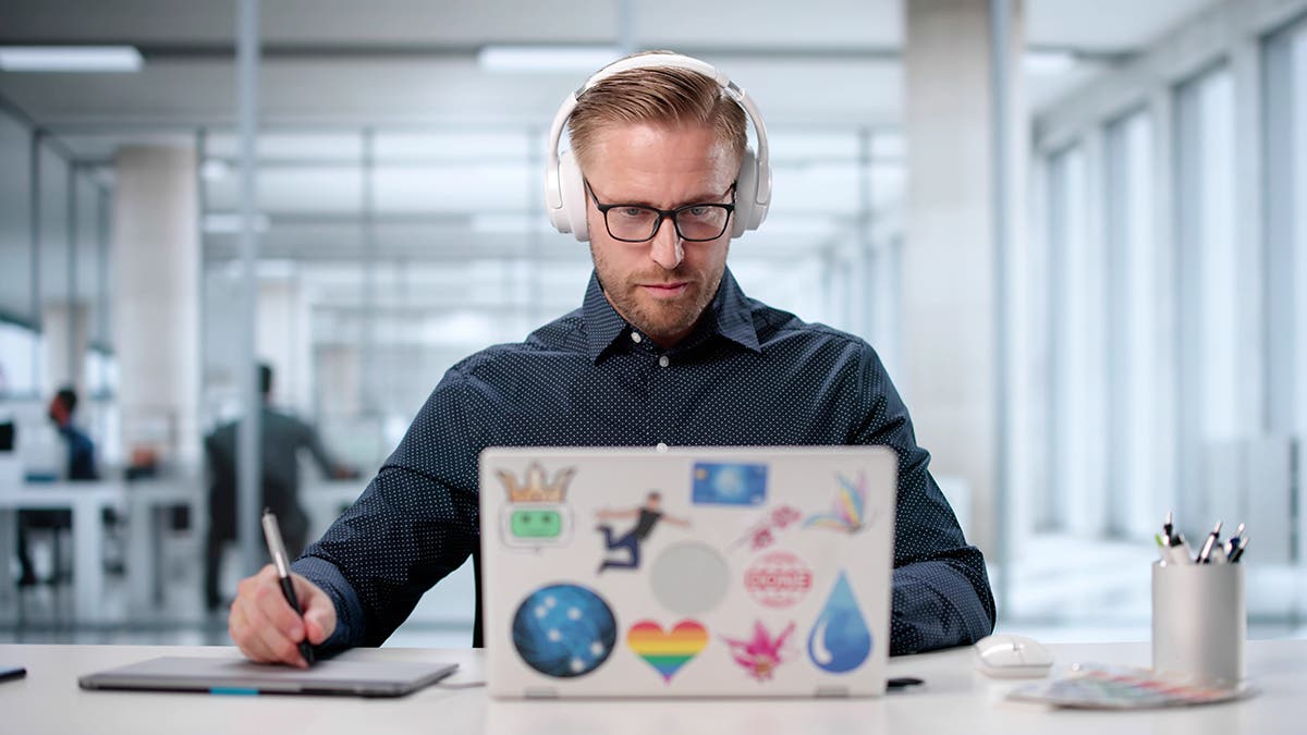 Male Graphic Designer Using Laptop To Edit Web Print Design