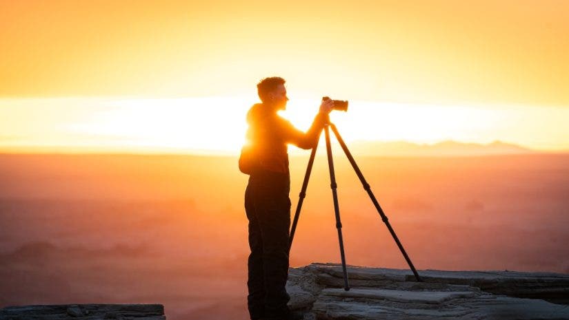 a photographer being backlit by a sunset