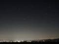 Night sky with stars above a small city showing the light pollution gradient of a Bortle 4/5 location