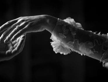 woman wearing wedding dress reaches for husband's hand