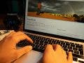 person typing on his laptop, building his photography website
