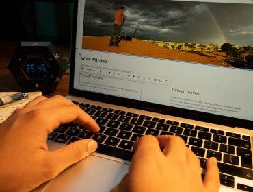 person typing on his laptop, building his photography website