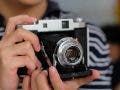 photographer holds vintage camera in his hands