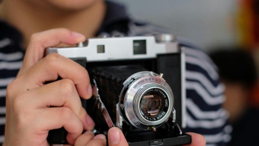 photographer holds vintage camera in his hands