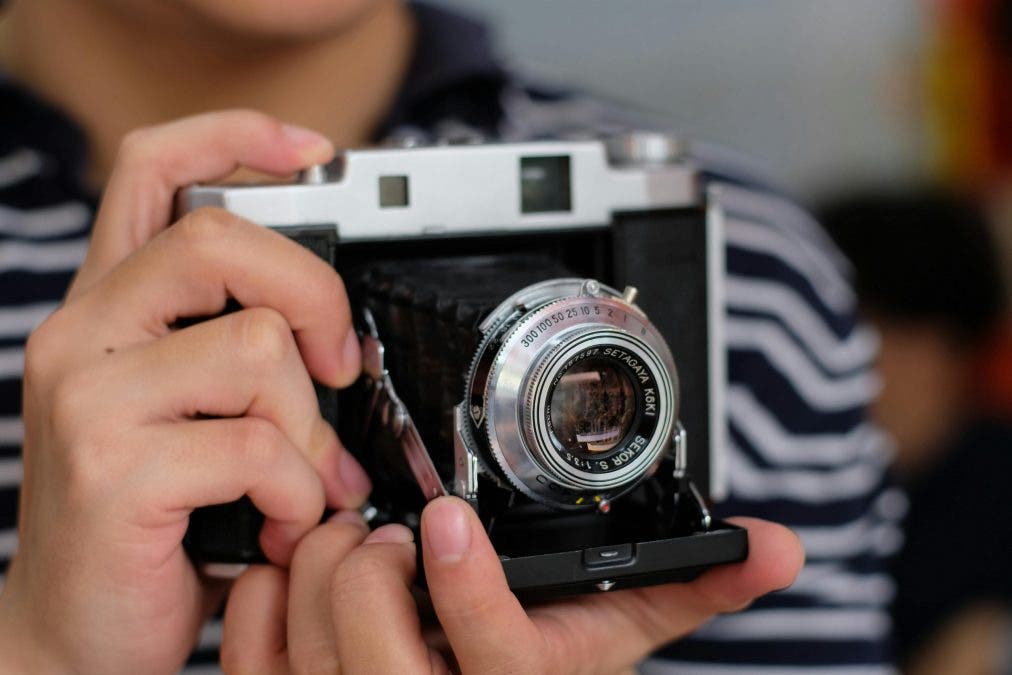 photographer holds vintage camera in his hands