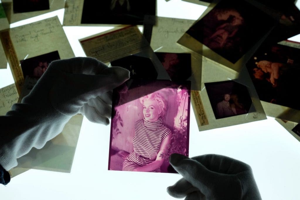 A curatorial assistant holding colour transparencies by the photographer Baron, depicting Marilyn Monroe, at the Getty Images Hulton Archive, London E16, 12th September 2023. (Photo by Chris Furlong/Getty Images)