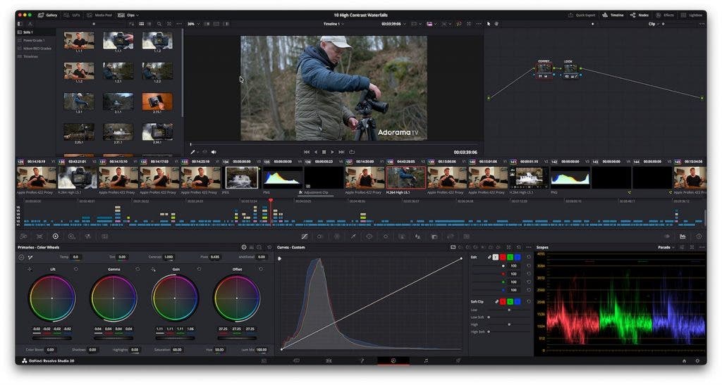 DaVinci Resolve software interface on the Color page, editing a shot of a man adjusting a camera in front of a waterfall. The workspace features a node graph in the upper right, and the bottom panel displays primary color wheels, a custom curve adjustment graph, and an RGB parade video scope.