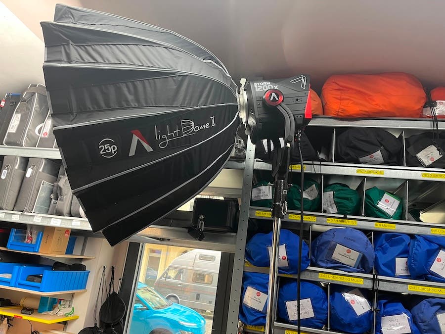 Aputure STORM 1200x continuous LED light mounted on a C-stand with a large Aputure Light Dome II softbox attached inside a gear rental facility