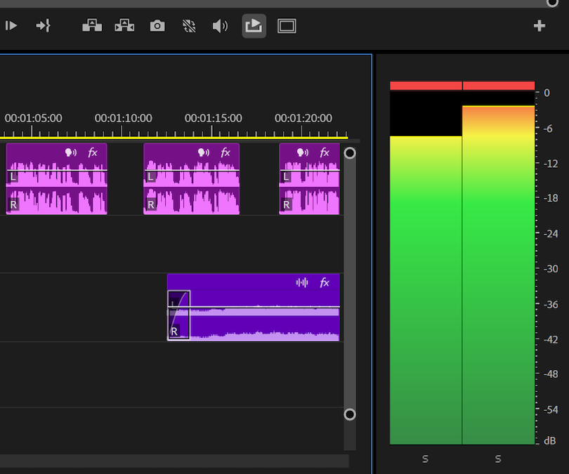 A close-up view of a video editing timeline displaying short, purple audio clips with visible waveforms. To the immediate right of the timeline is a large, vertical dual-channel master decibel meter, with levels illuminated in green, yellow, and red, showing the audio volume peaking near the top of the scale.