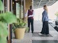 Doorman of the hotel meeting the guest and opening door for her