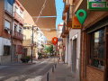 Street of local shops with three location pins marking three places to find photography clients