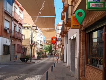 Street of local shops with three location pins marking three places to find photography clients