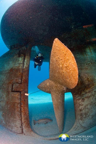 Cayman Island wreck dive. I chose to photograph near the propeller with a diver to show a sense of scale and drama.
