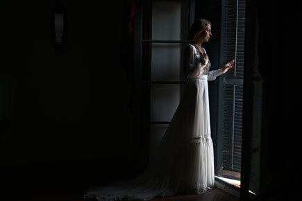 Nikon NIKKOR Z 35mm f/1.8 S Lens 18 woman looking out a window in a dark room taken with Nikon Z 35mm