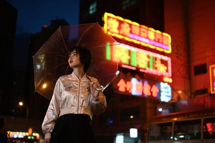 japanese model holding a clear umbrella with blurred background