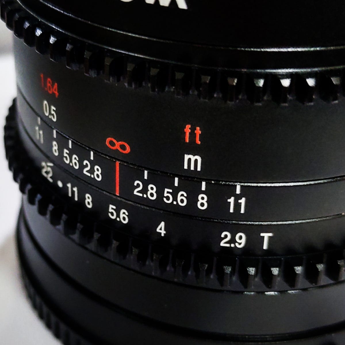 Both imperial and metric scale printed on the lens body.